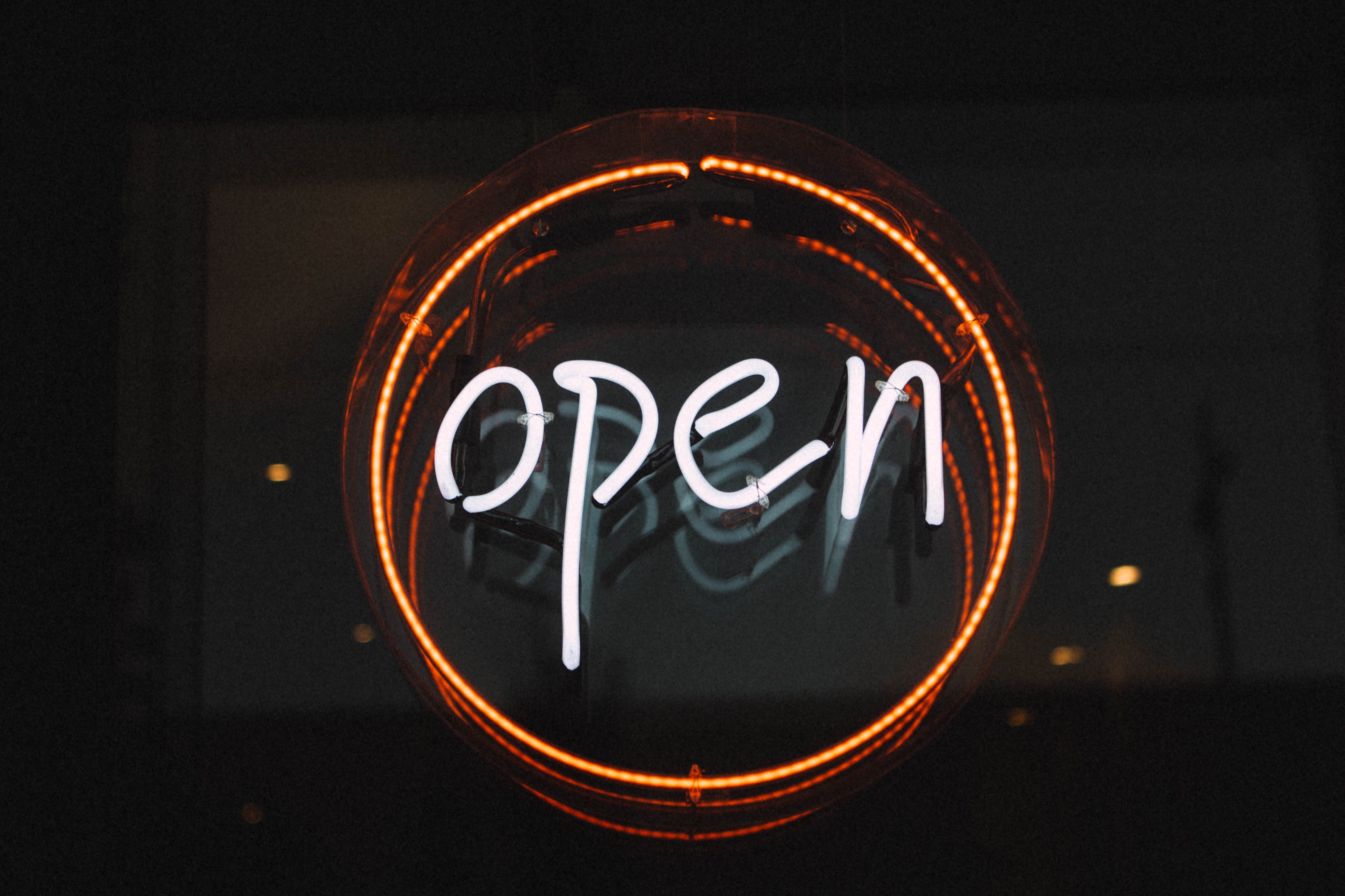 Photo of a glowing circular neon "open" sign